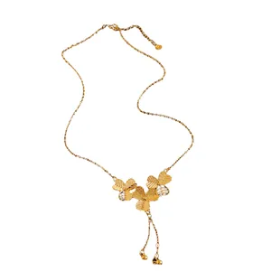 Elegant gold plated floral tassel necklace featuring dainty three-leaf clover charms for women
