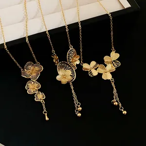 Detailed view of three gold-plated Chinese-style floral tassel necklaces on black background