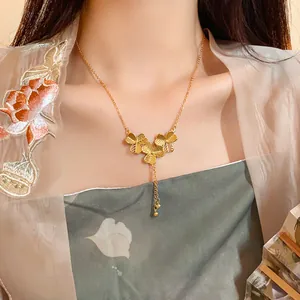 Close-up of gold-plated flower tassel necklace on model in elegant Chinese style