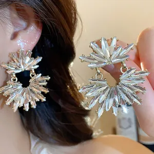 Close-up of elegant gold-toned sunburst earrings with sparkling marquise crystal detailing