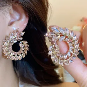 Close-up detail of sparkling wheat ear shaped earrings with champagne marquise stones.