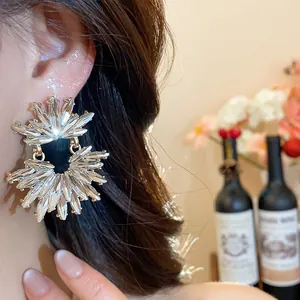 Detailed macro shot of sparkling double-layer crystal sunburst stud earrings on model