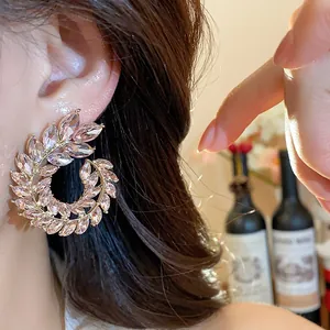 Detailed macro view of elegant wheat ear shaped earrings with shimmering pink crystals