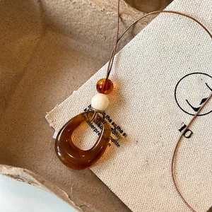 Elegant retro amber resin hollow pendant necklace on a long cord, perfect sweater chain