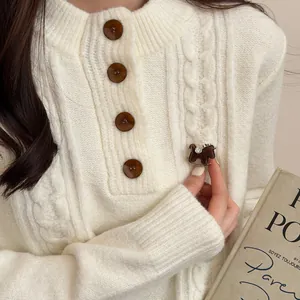 Detailed view of a brown flocked horse brooch with rhinestones pinned to a white sweater