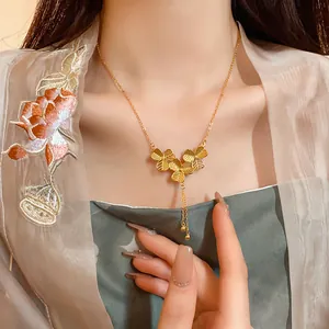 Macro view of an elegant gold-plated flower tassel necklace on a model collarbone