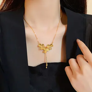 Elegant gold-plated floral tassel necklace showcased on a female model's neckline