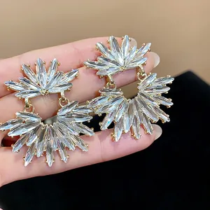 Close-up detail of sparkly rhinestone sunburst stud earrings with elegant silver needle
