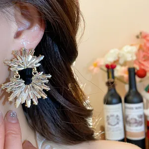 Macro detail shot of a sparkling wheat-ear shaped rhinestone stud earring on model