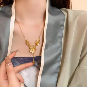 Close-up of gold-plated Chinese style necklace with flower and fan tassels