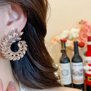 Detailed close-up showing elegant pink crystal wheat ear earrings worn on a model's ear