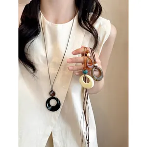 Close-up of minimalist hollow circular resin necklace on model with multi-color options