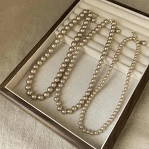 Three elegant pearl necklaces with different bead sizes displayed in a jewelry tray