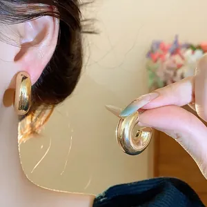 Minimalist chunky C-shaped gold hoop earrings for a stylish everyday look.