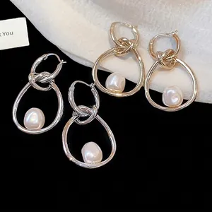 Elegantes pendientes de aro anudados con perlas barrocas en acabados plata y oro.