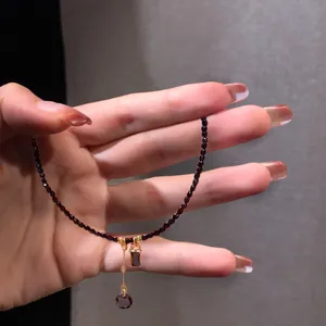 Detail showing elegant black crystal necklace with teardrop and rectangle pendants