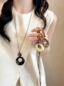 Detailed view of long resin necklaces with hollow round pendants in various colors