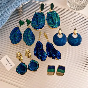 Vista dettagliata di vari orecchini pendenti blu druzy e perni vintage assortiti
