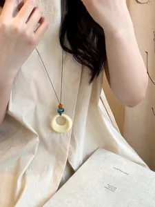 Close-up of retro hollow round resin necklace with beads in a lifestyle setting.