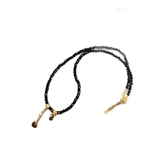 Elegant black crystal beaded necklace with a golden teardrop pendant and crystal detail
