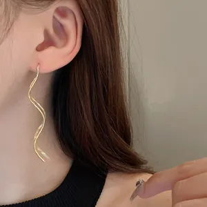 Detailed close-up showing the elegant gold plated wavy geometric ear threader earrings on model