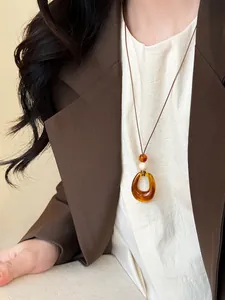 Elegant Neo-Chinese style resin pendant necklace on model wearing a brown blazer