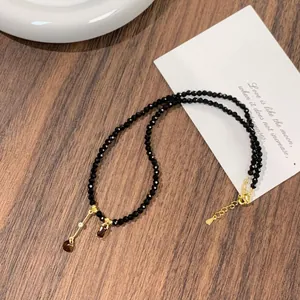 Close-up of faceted black crystal beads and gold teardrop pendant on necklace detail