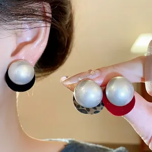 Elegant silver needle circular pearl stud earrings with black and red velvet backing