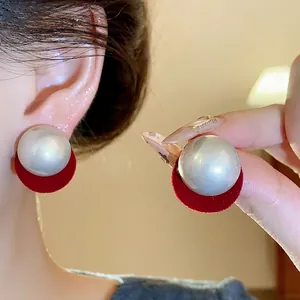 Elegant large pearl stud earrings with red velvet circular backing and silver needles