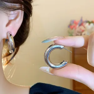 Detailed view of minimalist silver C-shaped hoop earrings for a stylish everyday look
