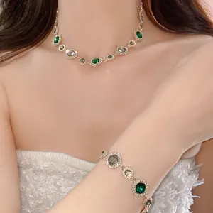 Gros plan d'un collier et d'un bracelet en cristal émeraude vintage sur un mannequin