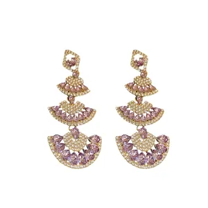 Elegant gold-tone tiered fan drop earrings with purple crystals and sparkling rhinestones.