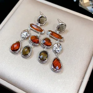 Elegant silver-needle drop earrings with faceted amber glass pendants