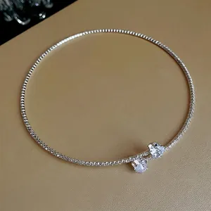 Minimalist silver-tone choker necklace featuring dual heart-shaped zircon crystal pendants