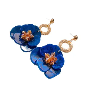 Eleganti orecchini a fiore blu con aghi d'argento e centro in cristallo ambrato.