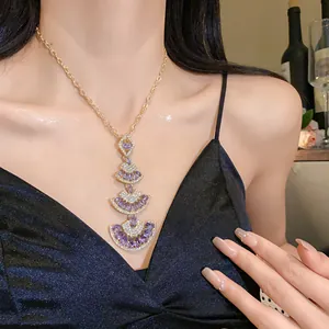 Elegant gold necklace with layered purple fan-shaped crystal pendants on model