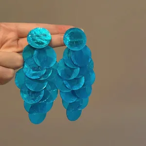 Macro dettaglio della texture degli orecchini pendenti a fiori con paillettes blu
