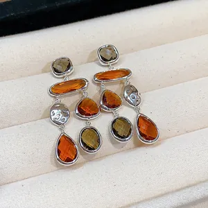 Detail view of vintage glass drop earrings with amber and olive pendants in a tray.