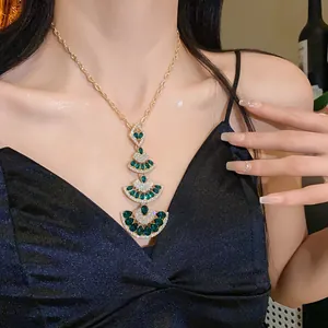 Detailed close-up of a multi-layered fan-shaped necklace with elegant green gems