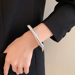 Bracelet jonc ouvert géométrique irrégulier argenté minimaliste porté au poignet