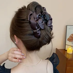 Primo piano di un fermaglio per capelli di lusso in raso marrone scuro in uno chignon