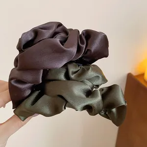 Primo piano di fermagli per capelli in raso stile francese in marrone e verde oliva
