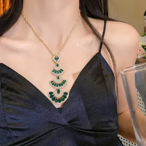 Detailed shot of a tiered emerald green fan-shaped pendant necklace with rhinestones