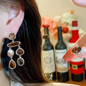 Detail shot of elegant vintage amber glass drop earrings and matching cocktail ring