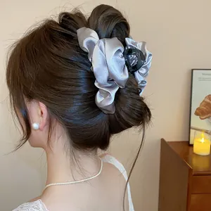 Vista dettagliata di un'elegante pinza per capelli in raso grigio in stile francese