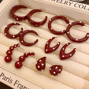 Detail view of retro burgundy polka dot earring set with glossy finish on jewelry tray