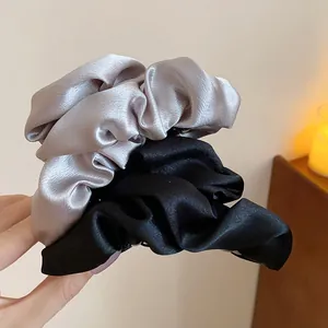Primo piano di eleganti fermagli per capelli in raso nei classici colori nero e grigio argento