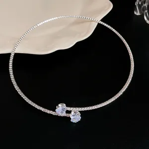 Detail view of a minimalist silver choker necklace featuring two zircon heart charms.