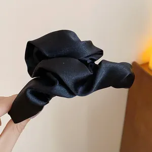 Primo piano di un fermaglio per capelli in raso nero arricciato stile francese