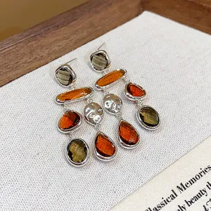 Macro detail view of vintage teardrop earrings with multi-colored faceted glass stones